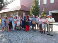 Gruppe von Menschen stehen vor alten Backsteingebäuden im Bauhaus-Stil