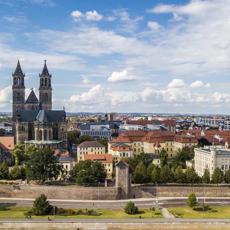 Blick auf die Stadt Magdeburg mit dem Dom und historischen Gebäuden unter blauem Himmel mit Wolken