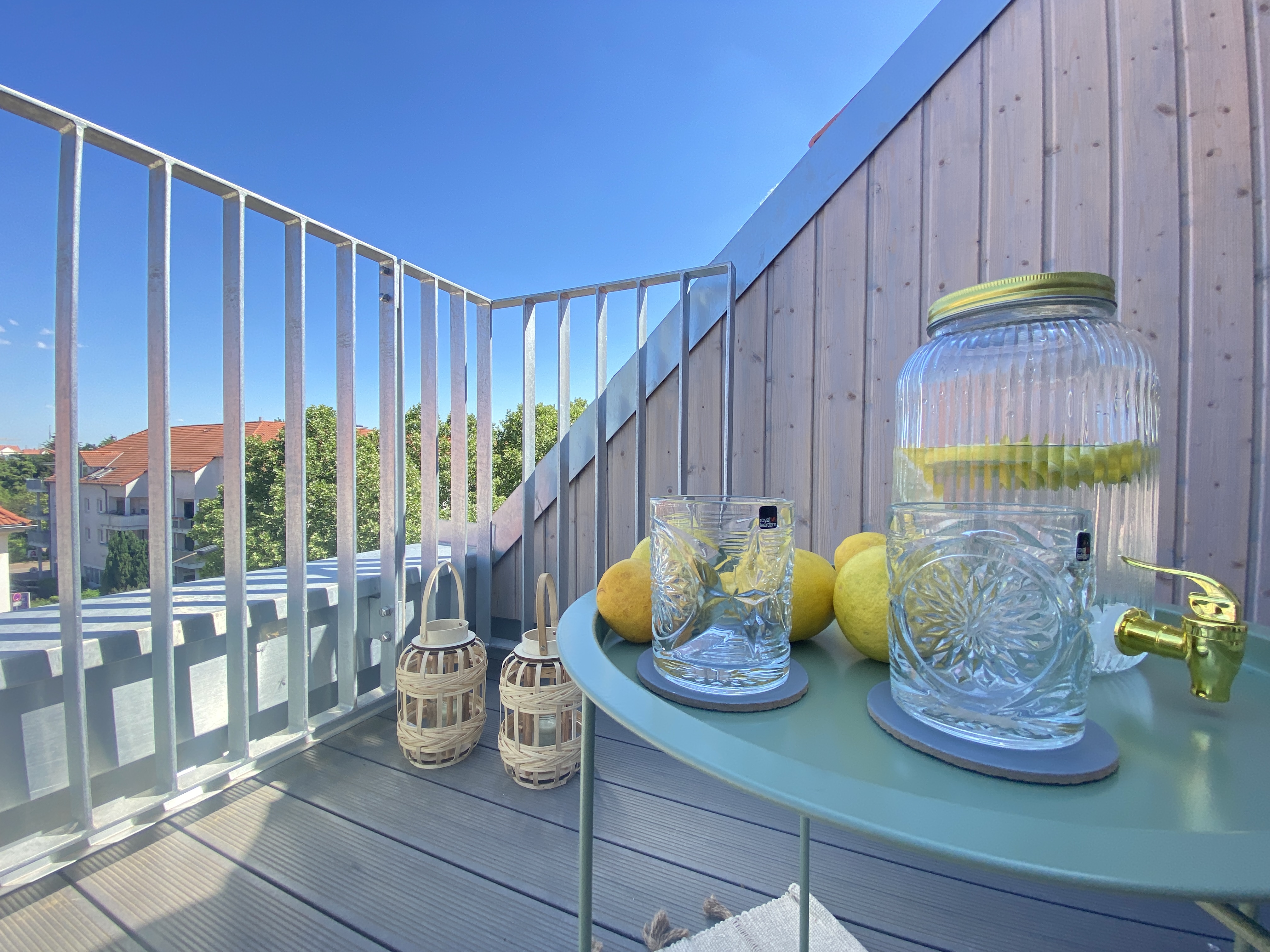 Balkon mit Tisch und dekorativen Elementen bei Sonnenschein