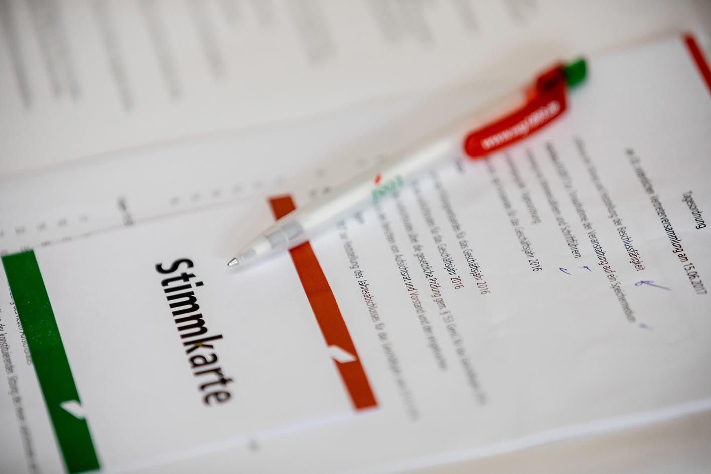 Stimmkarte und darüber liegt ein Kugelschreiber mit dem Logo der 1893 eG