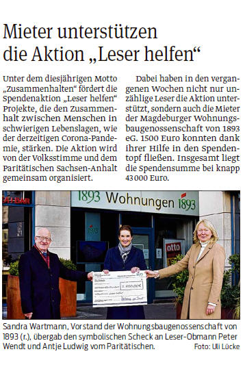 Drei Personen übergeben symbolischen Scheck vor Eingang der Wohnungsbaugenossenschaft von 1893