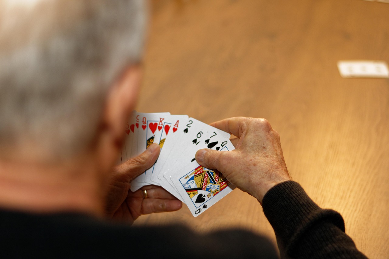 Älterer Mann hält Kartendeck aufgefächert in der Hand