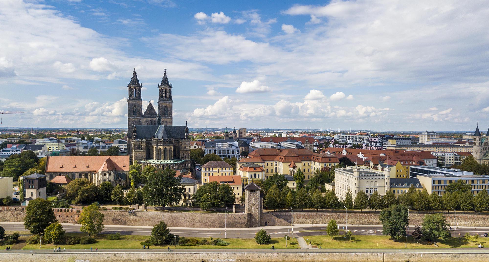 Blick auf die Stadt Magdeburg mit dem Dom und historischen Gebäuden unter blauem Himmel mit Wolken